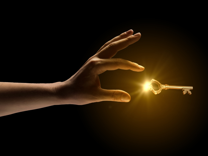 幸せになる鍵が光から輝いて飛び込んできているのを、まさに今キャッチしようとして親指と人差し指が開いている