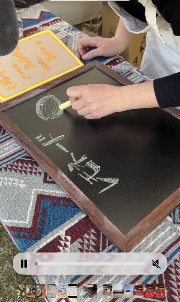 子どもが黒板にレモネードの案内を書いている